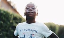 A happy black child confidently posing outdoors in Pretoria, South Africa.